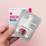 Hand holding a new package of Narcan