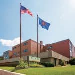 Exterior of hospital building with flagpoles and flags