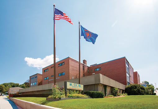 Exterior of hospital building with flagpoles and flags