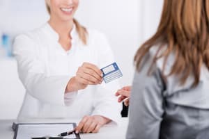 Nurse handing over insurance card